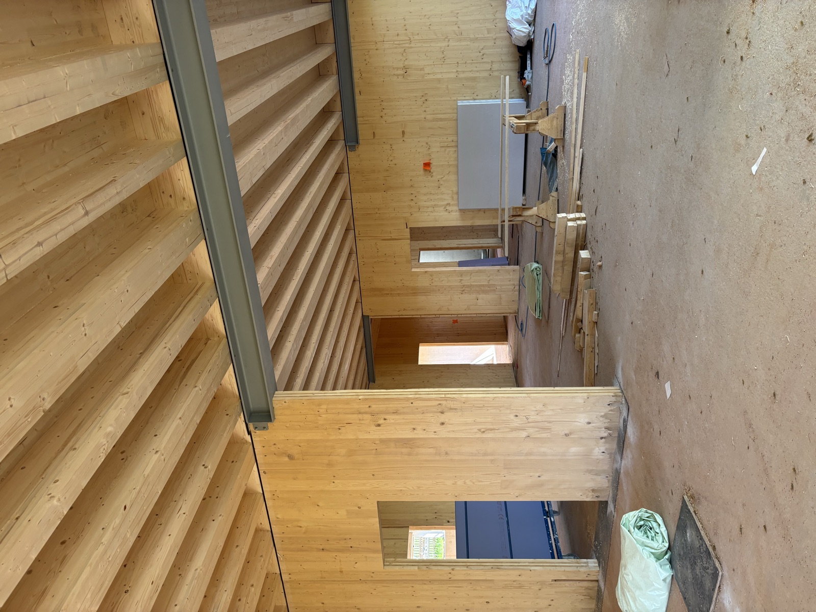 Gruppenraum des Kindergartens Hohenberg im Rohbau mit Brettsperrholz-Wänden und sichtbarer Holzbalkendecke