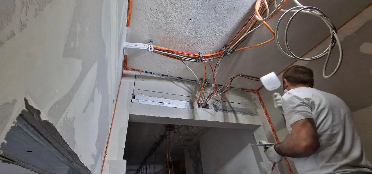 Trockenbau in Wasseralfingen: Bauarbeiter arbeitet an der Installation von Kabeln in einem Trockenbauprojekt. Professionelle Innenausbau- und Trockenbaudienstleistungen in Neuler und Umgebung.