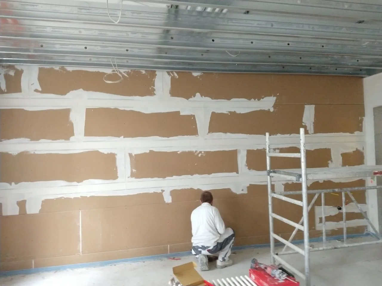 Trockenbau-Verfugung in Unterschneidheim: Bauarbeiter arbeitet an der Fertigstellung einer Wand mit verfugten Trockenbauplatten. Trockenbau- und Innenausbaudienstleistungen in Neuler und Umgebung.